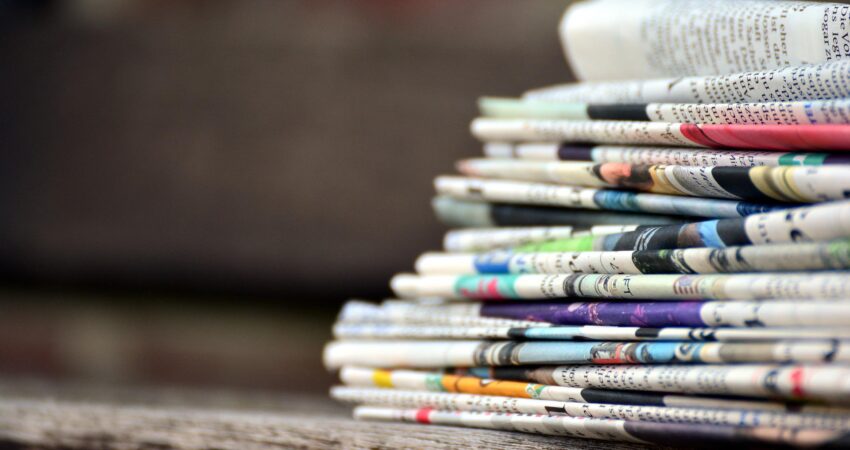 Das Foto zeigt einen Stapel Zeitungen.